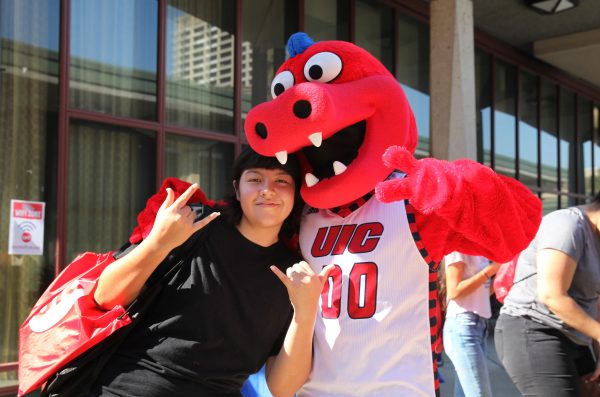 Student poses with Sparky the Dragon