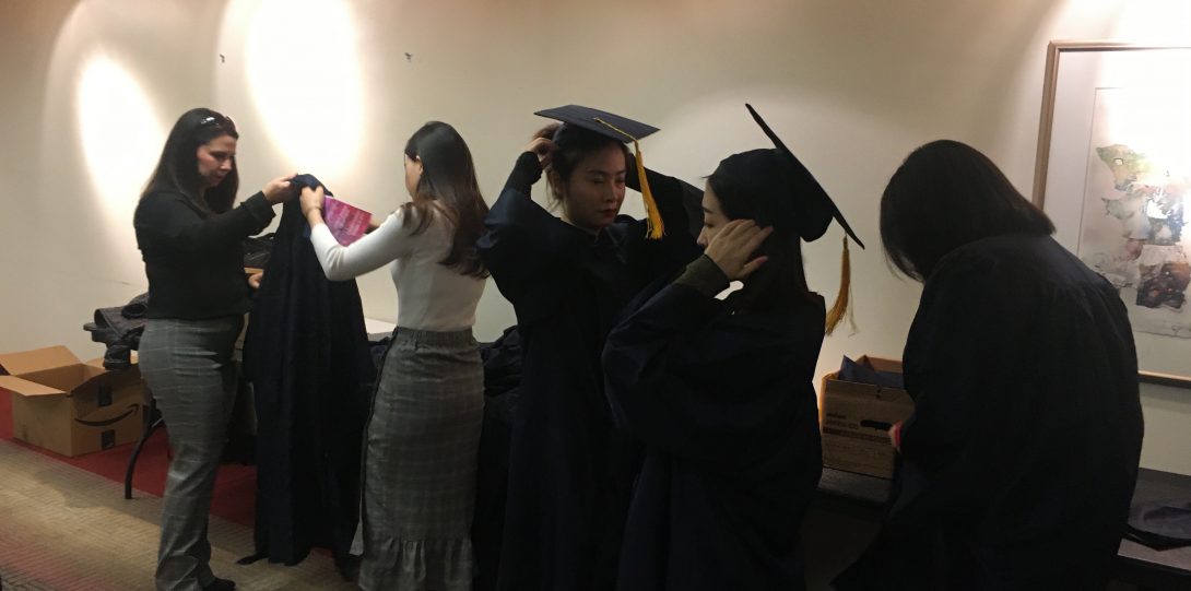 Students putting on regalia for graduation